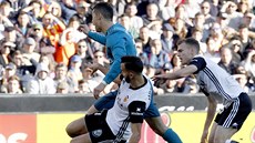 Martin Montoya z Valencie (v bílém vlevo) atakuje Cristiana Ronalda z Realu...