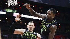 Mike Muscala (vlevo) a Dewayne Dedmon z Atlanty brání Iana Mahinmiho z...