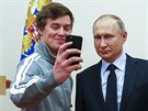 Ruský prezident Vladimir Putin se fotí se sportovci míícími na olympiádu do...