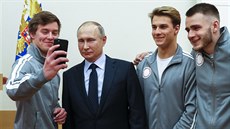 Ruský prezident Vladimir Putin se fotí se sportovci míícími na olympiádu do...