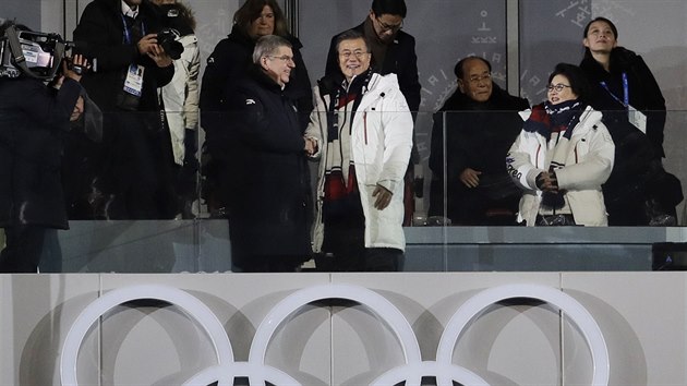 Prezident Jižní Koreje Mun Če-in (v bílém) si třese rukou s prezidentem MOV Thomasem Bachem. Vpravo nahoře sestra severokorejského diktátora Kim Jo-čong