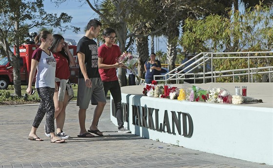 Lidé nosí kvtiny ke kole v Parklandu na Florid, kde bývalý student postílel...
