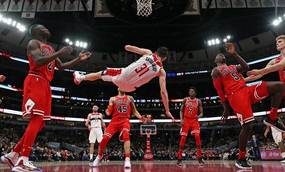 Tomá Satoranský z Washingtonu padá po faulu chicagského Bobbyho Portise.