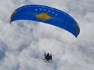 Paraglidista krouí nad Pritinou s národní vlajkou ped oslavami desátého...