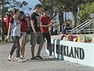 Lidé nosí kvtiny ke kole v Parklandu na Florid, kde bývalý student postílel...