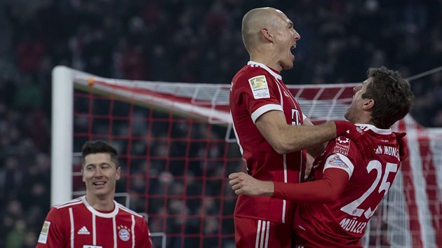 Glov radost fotbalist Bayernu Mnichov. Thomas Mller (vpravo) chyt Arjena Robbena, pihl Robert Lewandowski .