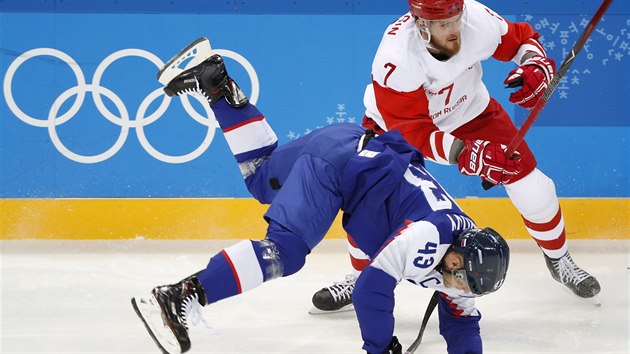 Slovensk hokejista Tom Surov (v modrm) pad po kolizi s Rusem Ivanem...