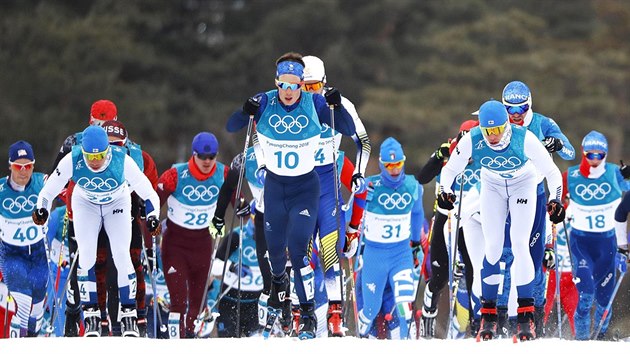 Bci ve skiatlonu na 15+15 kilometr krtce po startu v pchongchangskm Alpensia Cross-Country Skiing Centre. (11. nora 2018)