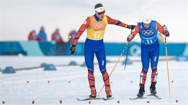 Čeští běžci Petr Knop (vlevo) a Michal Novák při předávce v olympijském štafetovém závodu na 4 x 10 km. (18. února 2018)