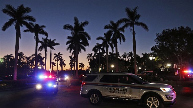 Policejní vozy přijíždějí k hotelu, v němž si po střelbě na střední škole rodiče měli své děti. (14. února 2018)
