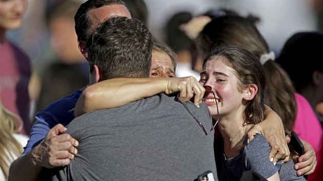 Rodiče objímají své děti, které přežily střelbu na střední škole ve floridském Parklandu. (14. února 2018)