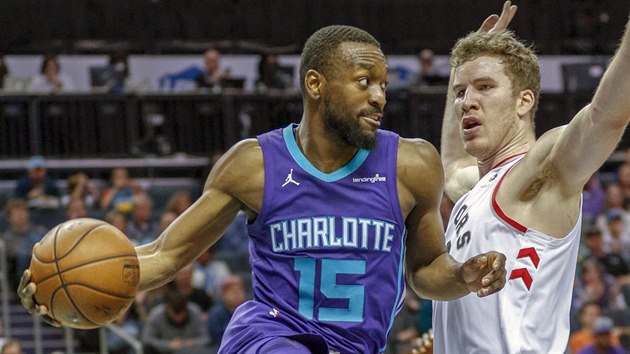 Kemba Walker (vlevo) z Charlotte pihrv kolem Jakoba Pltla z Toronta.