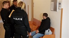 Policisté na chodbě Okresního soudu Plzeň-jih hlídají jednoho z Rumunů, kteří v...