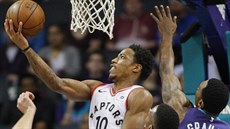 DeMar DeRozan (vlevo) z Toronta zakonuje donákou zpod koe kolem Treveona...