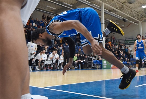 Devon Bookert z USK Praha padá na dínskou palubovku.