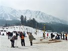 Vtina turist z Indie si pijede v zim osahat sníh nebo se svézt na saních....