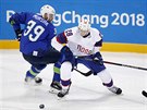 Norský hokejista Niklas Roest v souboji se Slovincem Janem Murakem. (20. února...