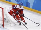eský hokejista Luká Radil bojuje o puk za brankou Ruska. (23. února 2018)