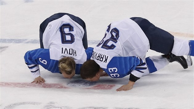 Finské hokejistky Venla Hoviová a Michelle Karvinenová líbají led na oslavu bronzové medaile z olympijského turnaje.