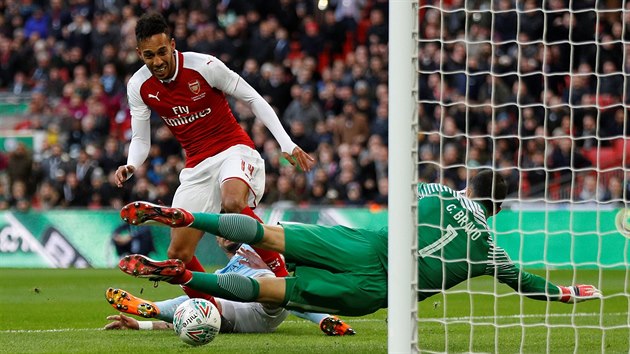 Claudio Bravo, gólman Manchester City zasahuje proti střele útočníka Pierre-Emericks Aubameyanga z Arsenalu