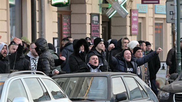 Skandujc fanouci Partizanu Blehrad proli s policejnm doprovodem z nmst Republiky a na fotbalov stadion. Cestu si zpestili pyrotechnikou (22. nora 2018)