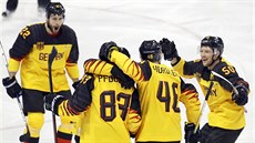 Němečtí hokejisté se radují z branky Leonhardem Pfoderlem (83) v olympijském...