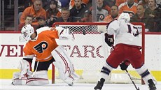 Branká Petr Mrázek z Philadelphie a Artemij  Panarin z Columbus sledují, kam...