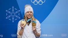 Dvojnásobná olympijská vítězka Ester Ledecká hrdě pózuje se zlatými medailemi.