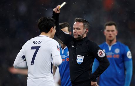 Korejský záloník Son z Tottenhamu Hotspur dostává lutou kartu, sudí Paul...