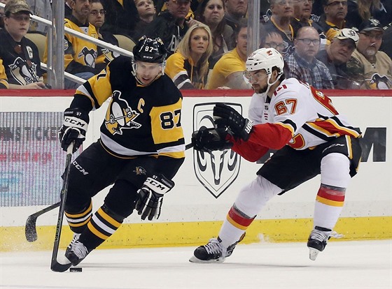 Sidney Crosby (vlevo) z Pittsburghu kontroluje puk, napadá Michael Frolík z...