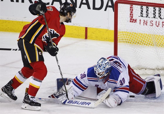 Michael Frolík z Calgary v anci ped brankáem New York Rangers Henrikem...