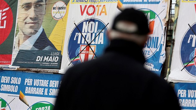 V Itálii se konají v neděli volby, muž stojí před plakáty stran v Pomigliano D'Arco (21. února 2018).