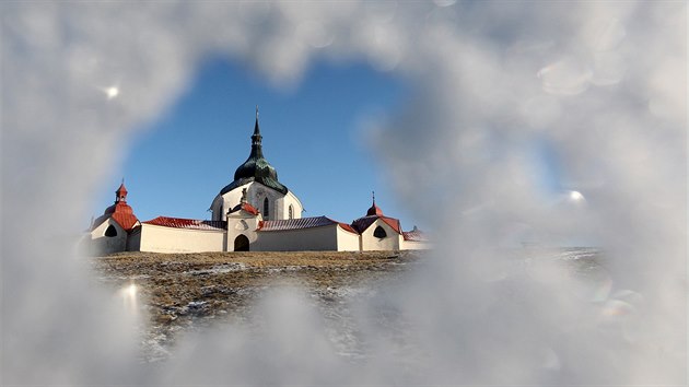 Poutn kostel sv. Jana Nepomuckho na Zelen Hoe ve e nad Szavou skrz zmrzl stromy.
