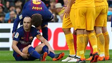 Andres Iniesta z Barcelony se zvedá z trávníku v utkání s Atletikem Madrid.