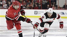 Brett Pesce z Caroliny pálí, Taylor Hall z New Jersey blokuje jeho stelu.