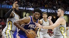 Joel Embiid (v modrém) bránný LeBronem Jamesem (vlevo) a Larrym Nancem Jr....