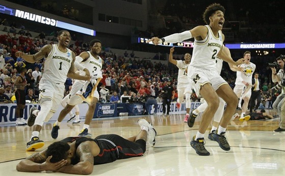 Jordan Poole (2) z Michiganu slaví se spoluhrái svou vítznou trojku, zato...