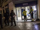 Policisté a lenové ochranky u rozbitých dveí do banky v Madridu