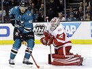 Tomá Hertl ze San Jose v anci ped brankáem  Jimmym Howardem z Detroitu.