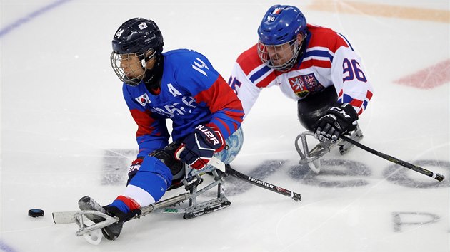 Jihokorejský sledge hokejista Jung Seung-hwan u puku, dotírá na něj Zdeněk Krupička.