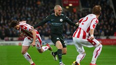 Joe Allen (vlevo) a Moritz Bauer ze Stoke se sna�í zastavit Davida Silvu z...