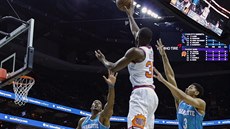 Davon Reed (v bílém) z Phoenixu zakonuje na ko Charlotte pes Dwighta Howarda...