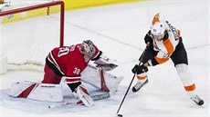 Jakub Voráek z Philadelphie zkouí vyzrát na gólmana Caroliny Cama Warda.