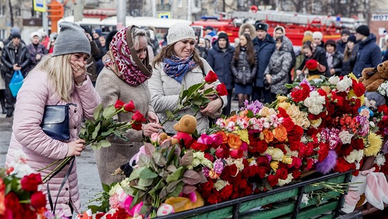 Lidé truchlí za obti poáru v obchodním dom v ruském mst Kemerovo....