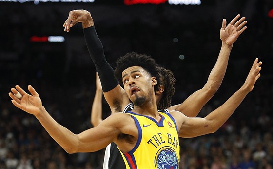 Quinn Cook (ve lutém) z Golden State neubránil Pattyho Millse ze San Antonia.