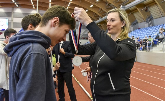 Barbora potáková pedává medaile na atletických závodech dtí.