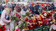 Lidé truchlí za obti poáru v obchodním dom v ruském mst Kemerovo....