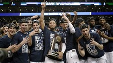 Jalen Brunson (uprosted) s trofejí pro regionální ampiony v NCAA. Jeho...