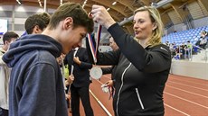Barbora potáková pedává medaile na atletických závodech dtí.