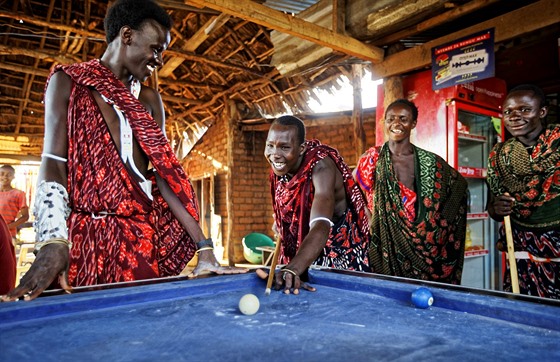 RELAXACE. Mladí masajští mužové tráví pozdní odpoledne hraním kulečníku v baru u cesty. 